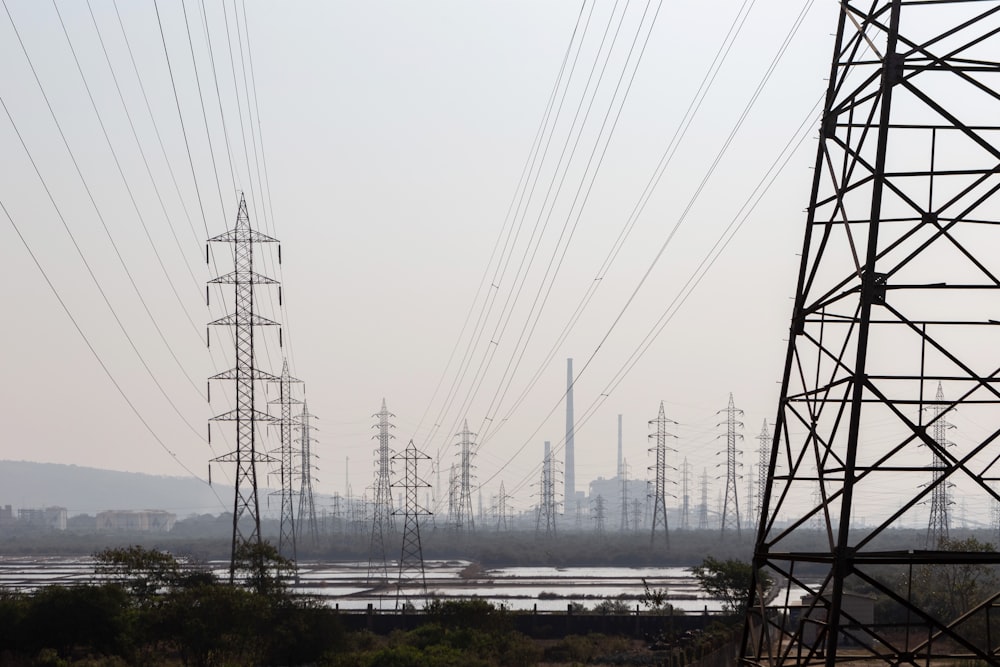 black electric towers on green grass field during daytime