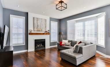 gray couch on brown wooden parquet flooring