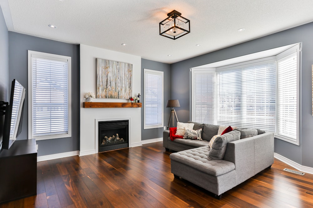 gray couch on brown wooden parquet flooring