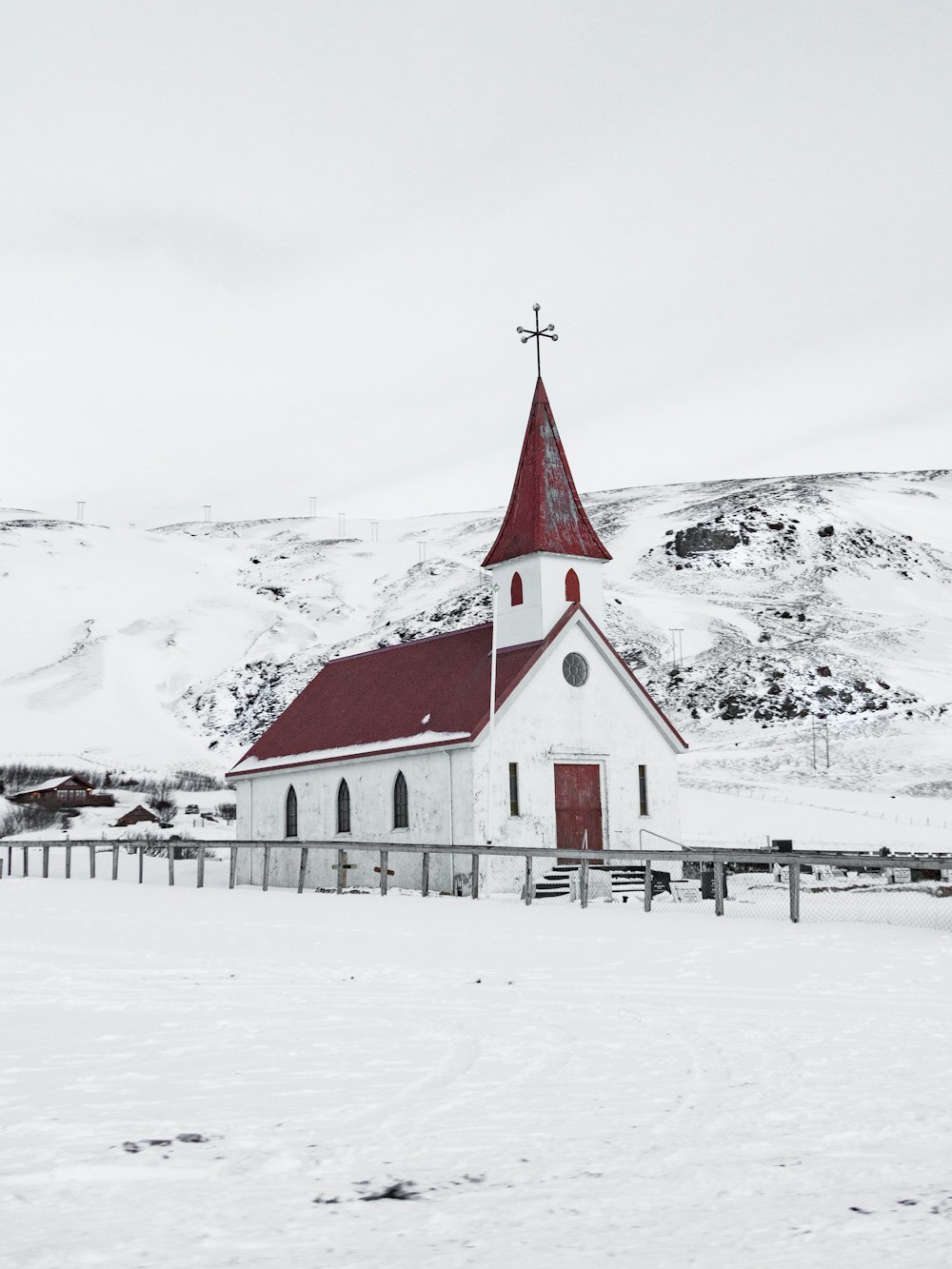 雪に覆われた地面に白と赤の教会