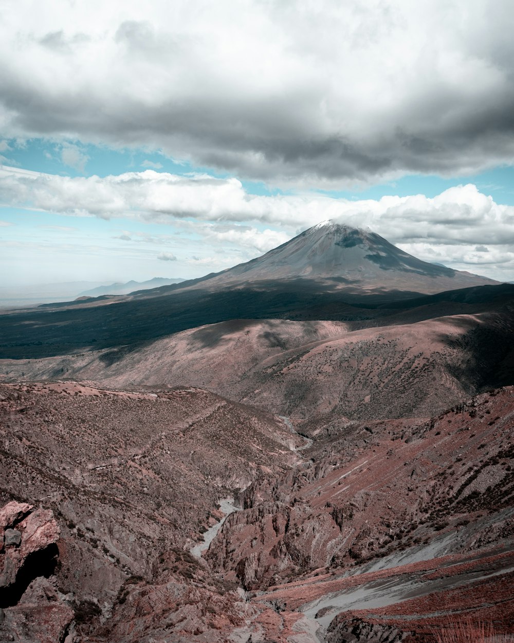 brown and gray mountain under white clouds and blue sky during daytime