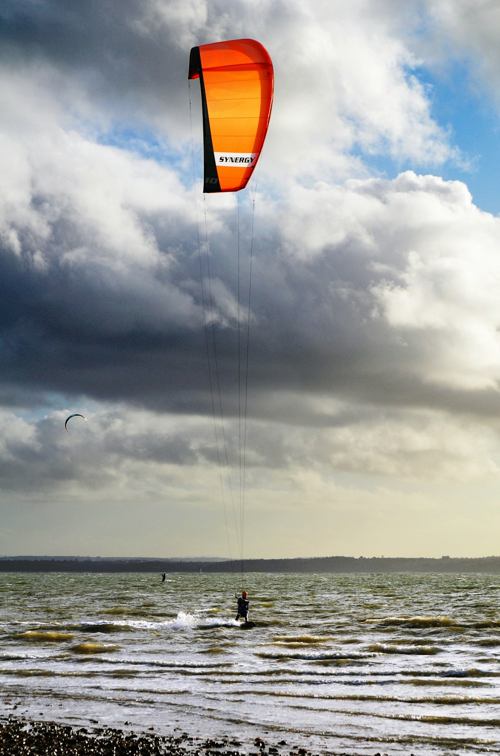 person in black shirt and black pants holding orange and yellow kite