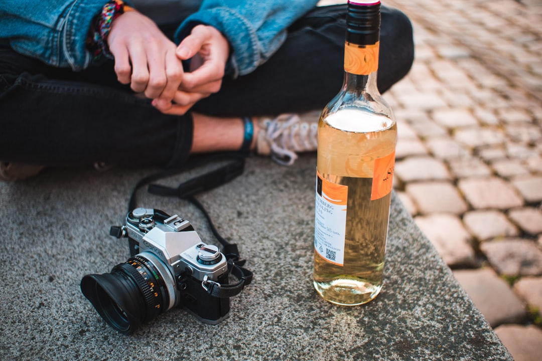 person holding bottle with brown liquid