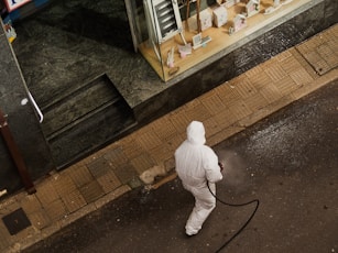man in white thobe walking on sidewalk during daytime