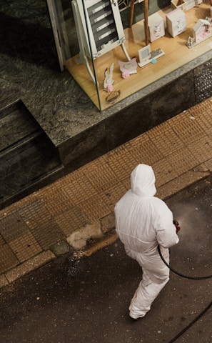 man in white thobe walking on sidewalk during daytime