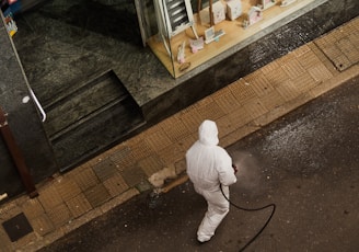 man in white thobe walking on sidewalk during daytime