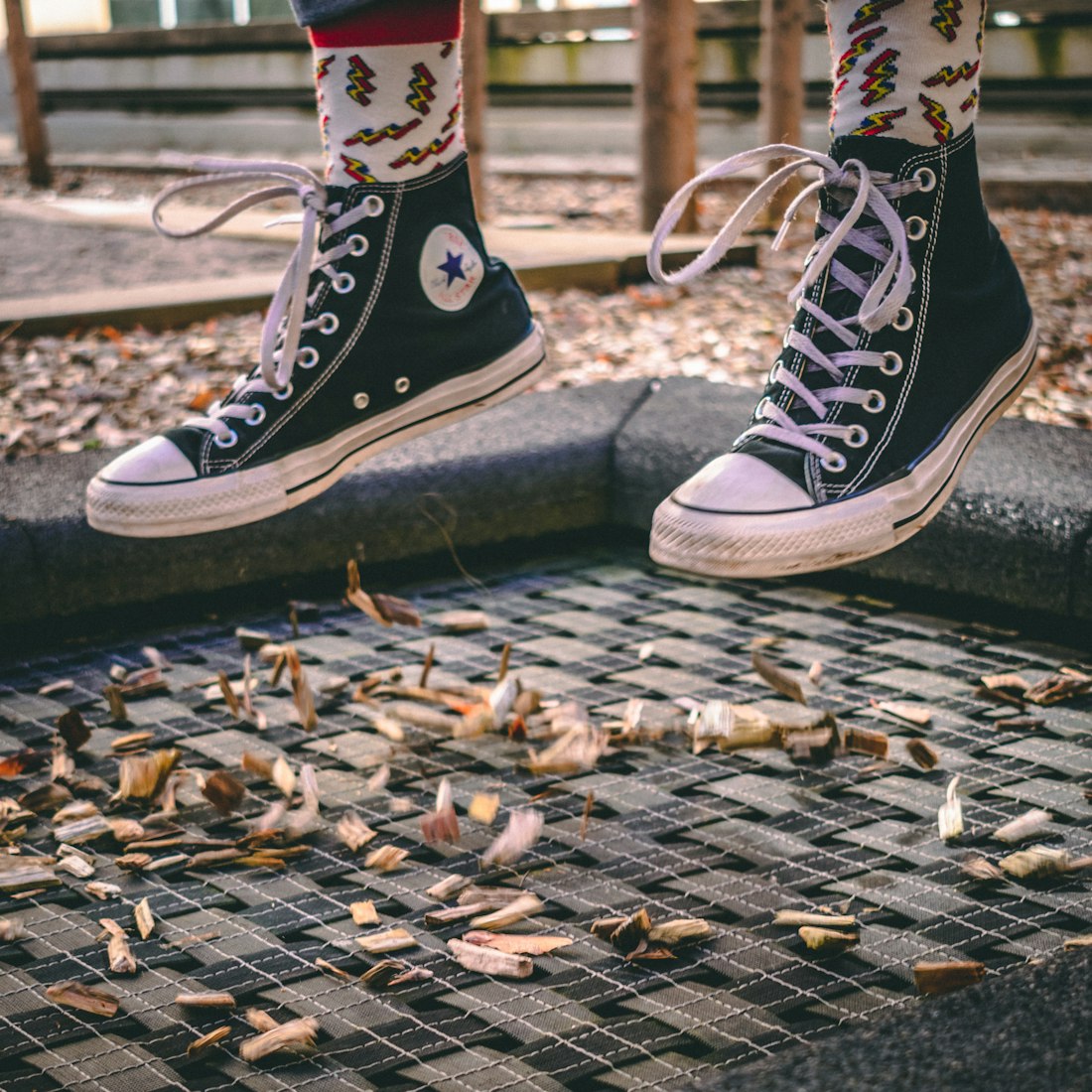 black converse and fun socks mid air