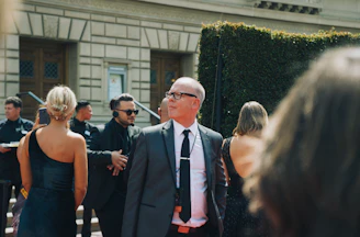 man in black suit standing beside woman in black sleeveless dress