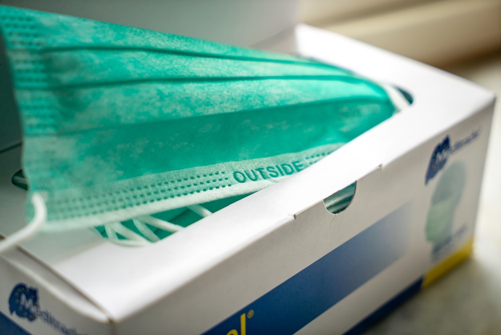 bandeja de plástico verde azulado en un recipiente de plástico blanco y azul