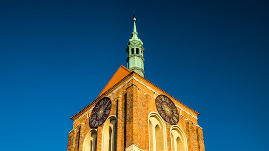 brown and beige concrete building under blue sky during daytime in Gdańsk Poland