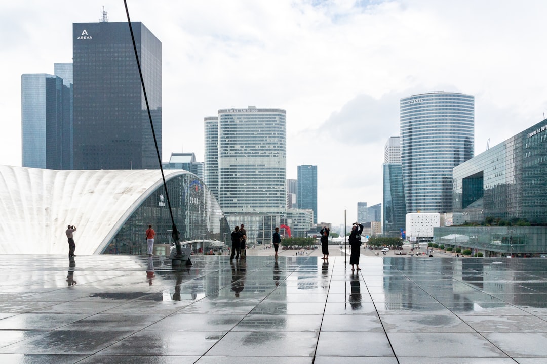 people walking on sidewalk near high rise buildings during daytime