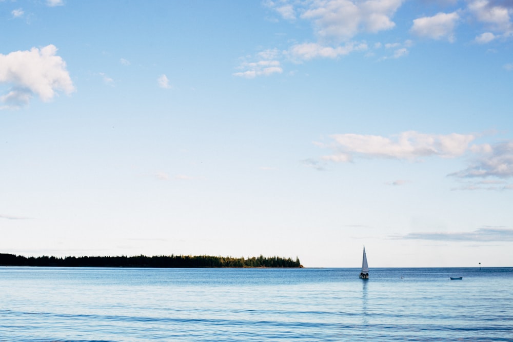 sailboat on sea under blue sky during daytime