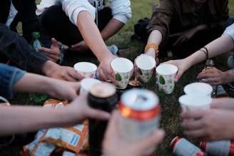 people holding white plastic cups
