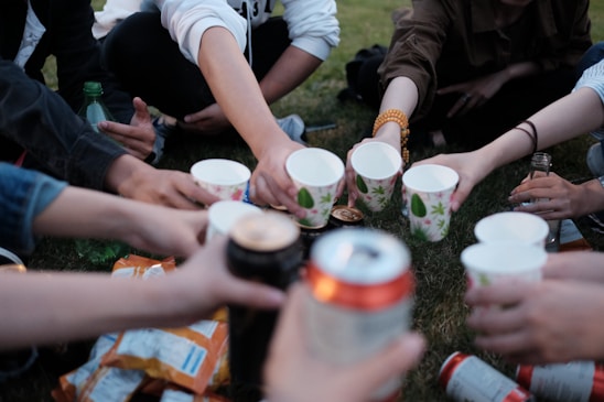 people holding white plastic cups