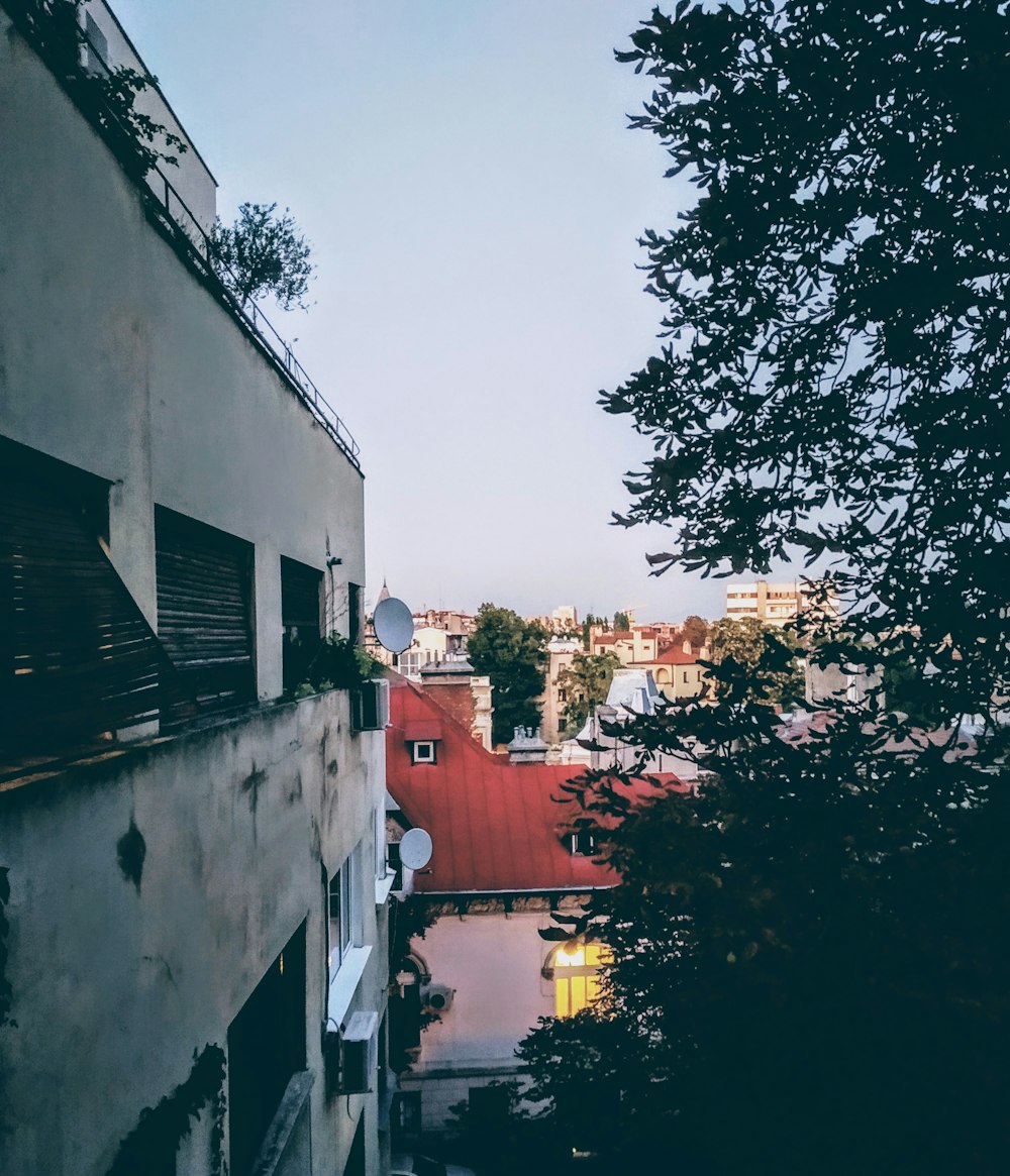 red and white concrete building near green trees during daytime