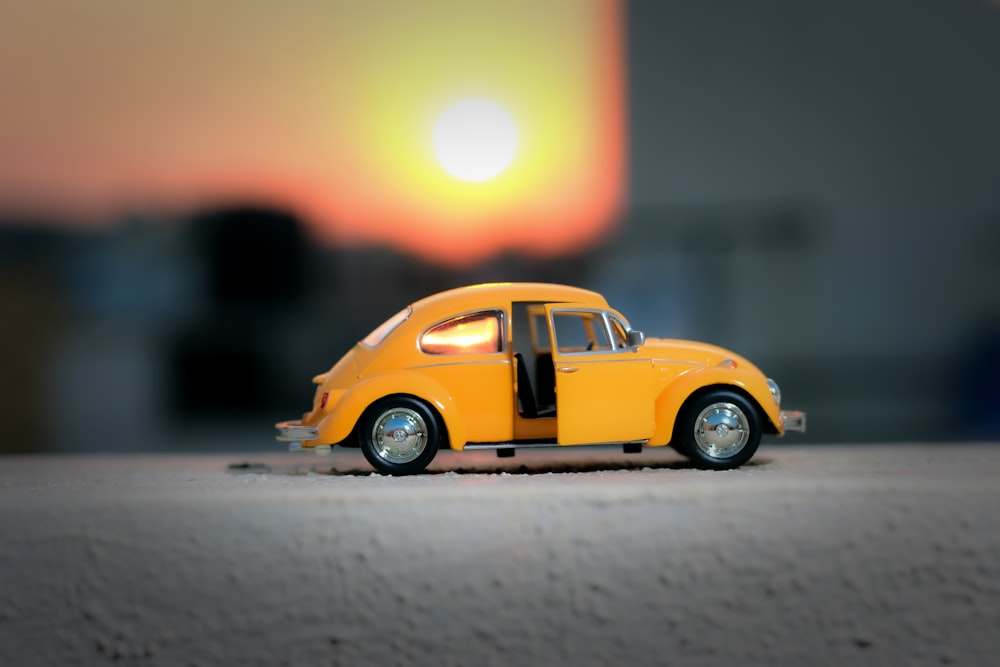 Volkswagen Beetle amarillo en la carretera durante la puesta de sol
