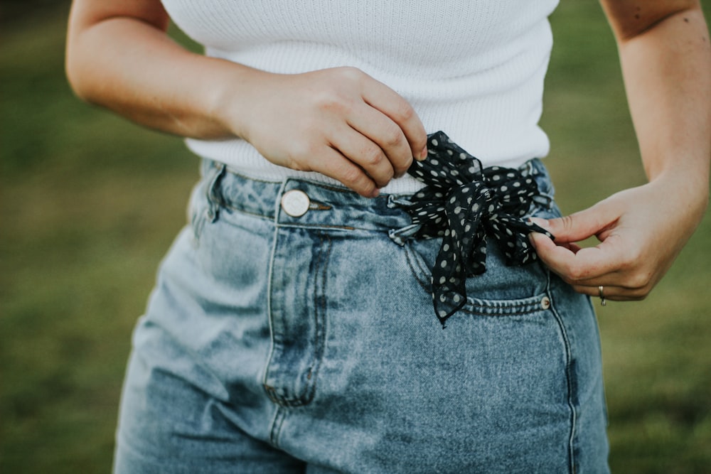 person in white shirt and blue denim jeans