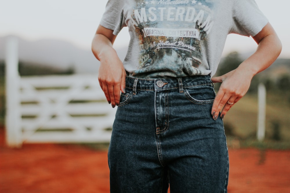 man in white and black crew neck t-shirt and blue denim jeans