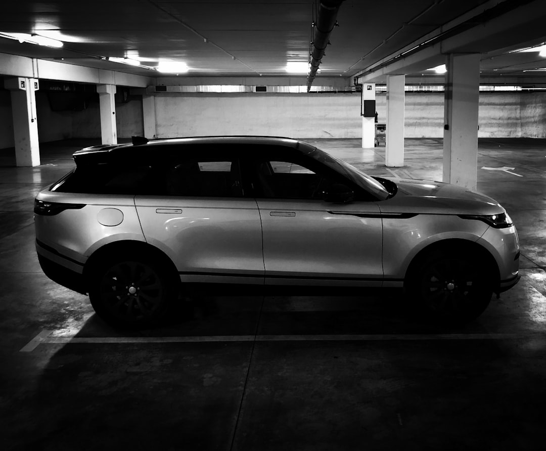 grayscale photo of car in parking lot