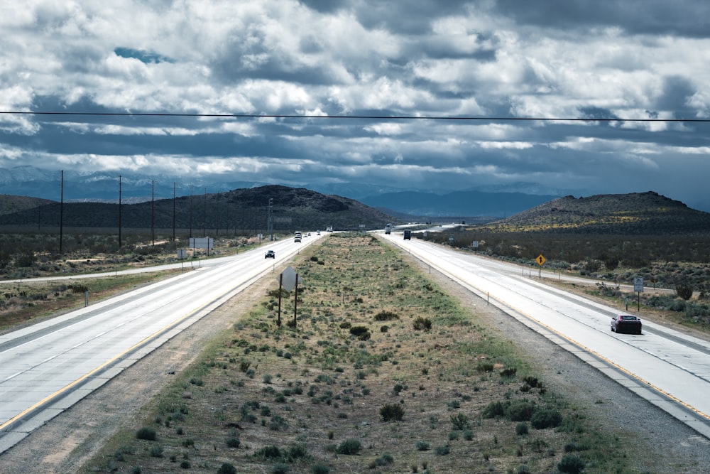 estrada de asfalto cinza sob céu nublado cinzento durante o dia