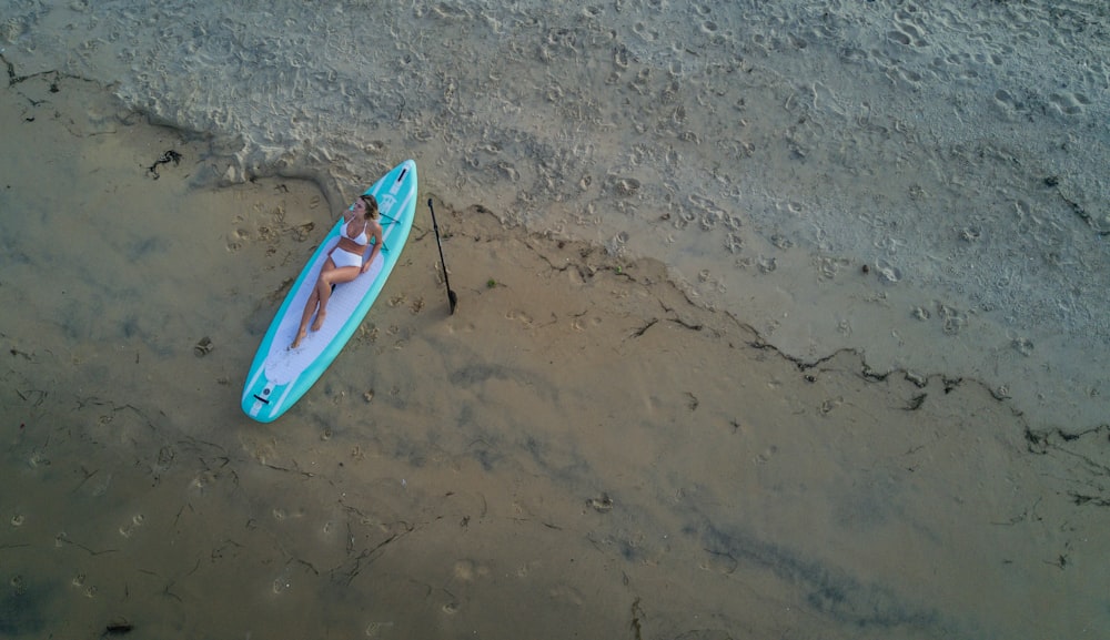 blue and red surfboard on brown sand