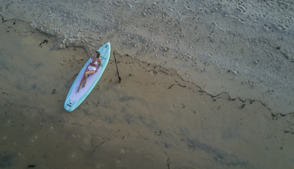 blue and red surfboard on brown sand