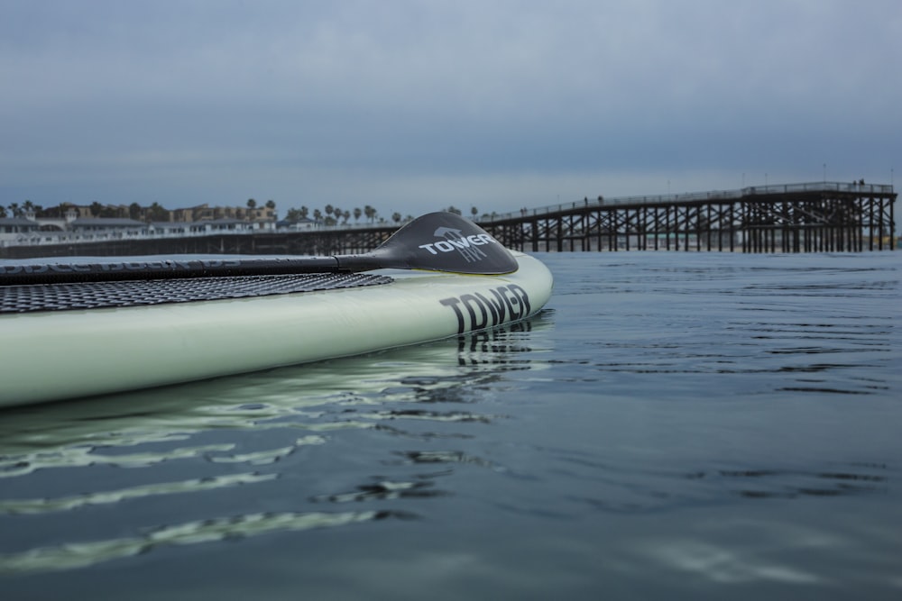 Weißes und schwarzes Surfbrett auf blauem Wasser