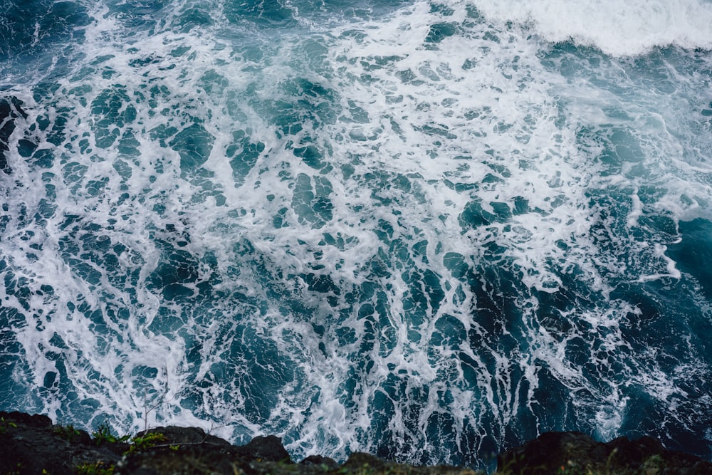 ocean waves crashing on rocky shore during daytime