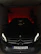 A polished Mercedes-Benz inside a dark, stylish garage with subtle red lighting accents.