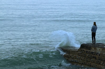 brown rock formation on sea during daytime sadness zoom background