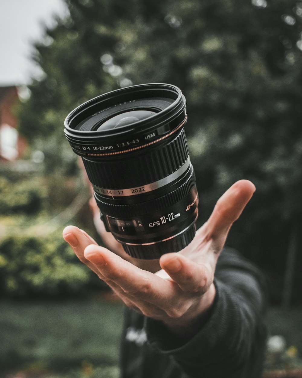 person holding black camera lens