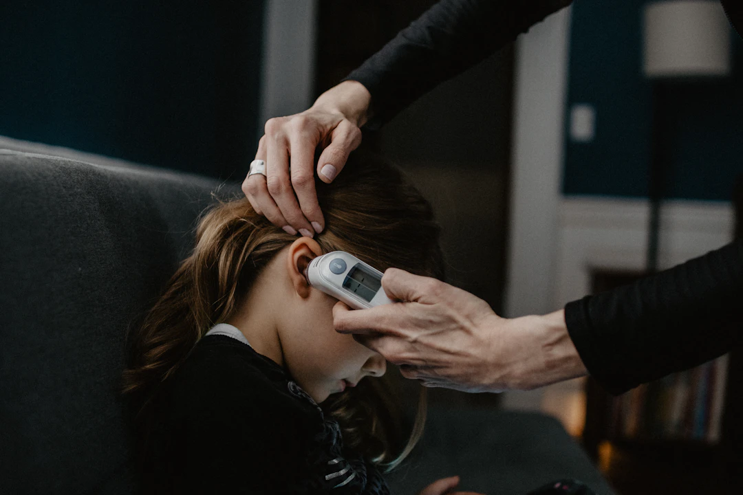 Mother taking her daughter's temperature