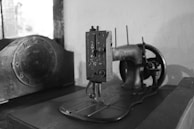 Vintage sewing machine alongside modern equipment showing evolution of our craft.