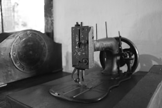 Vintage sewing machine alongside modern equipment showing evolution of our craft.