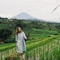 woman in gray long sleeve dress standing on green grass field during daytime