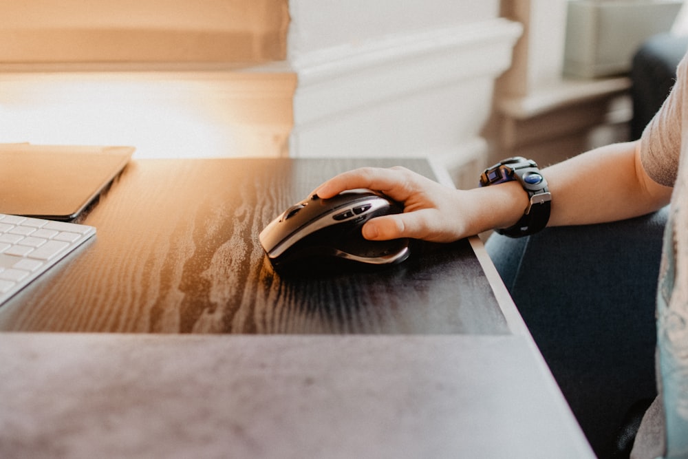 person holding black and brown cordless computer mouse