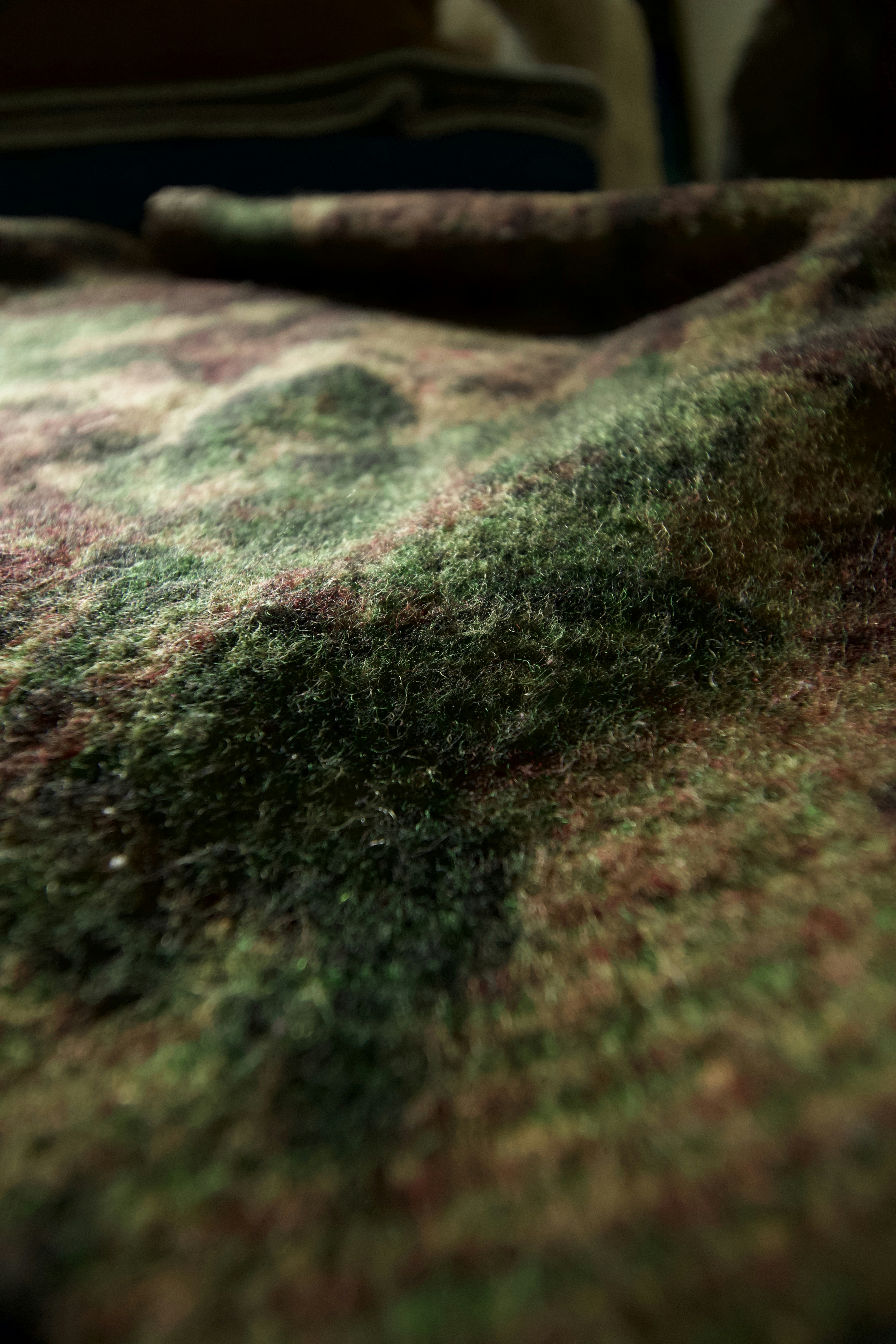 Close-up of textured fabric detail on canvas jacket collar, warm sand tones, soft focus background