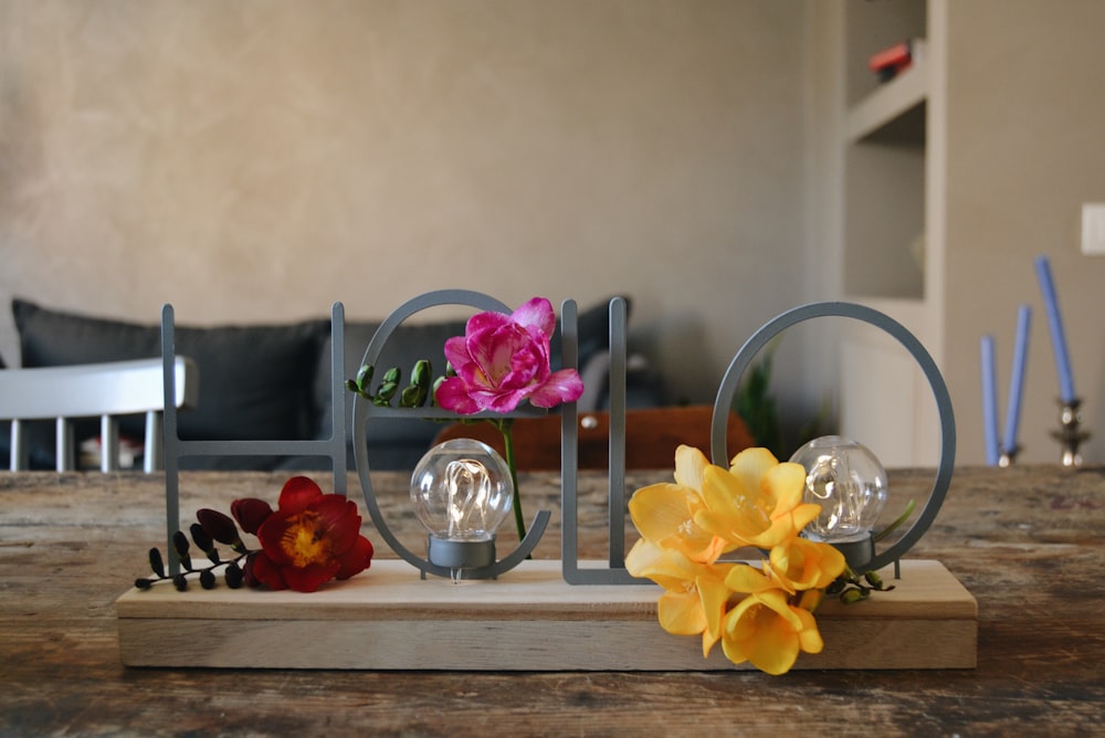 yellow and purple moth orchids in clear glass vase on brown wooden table