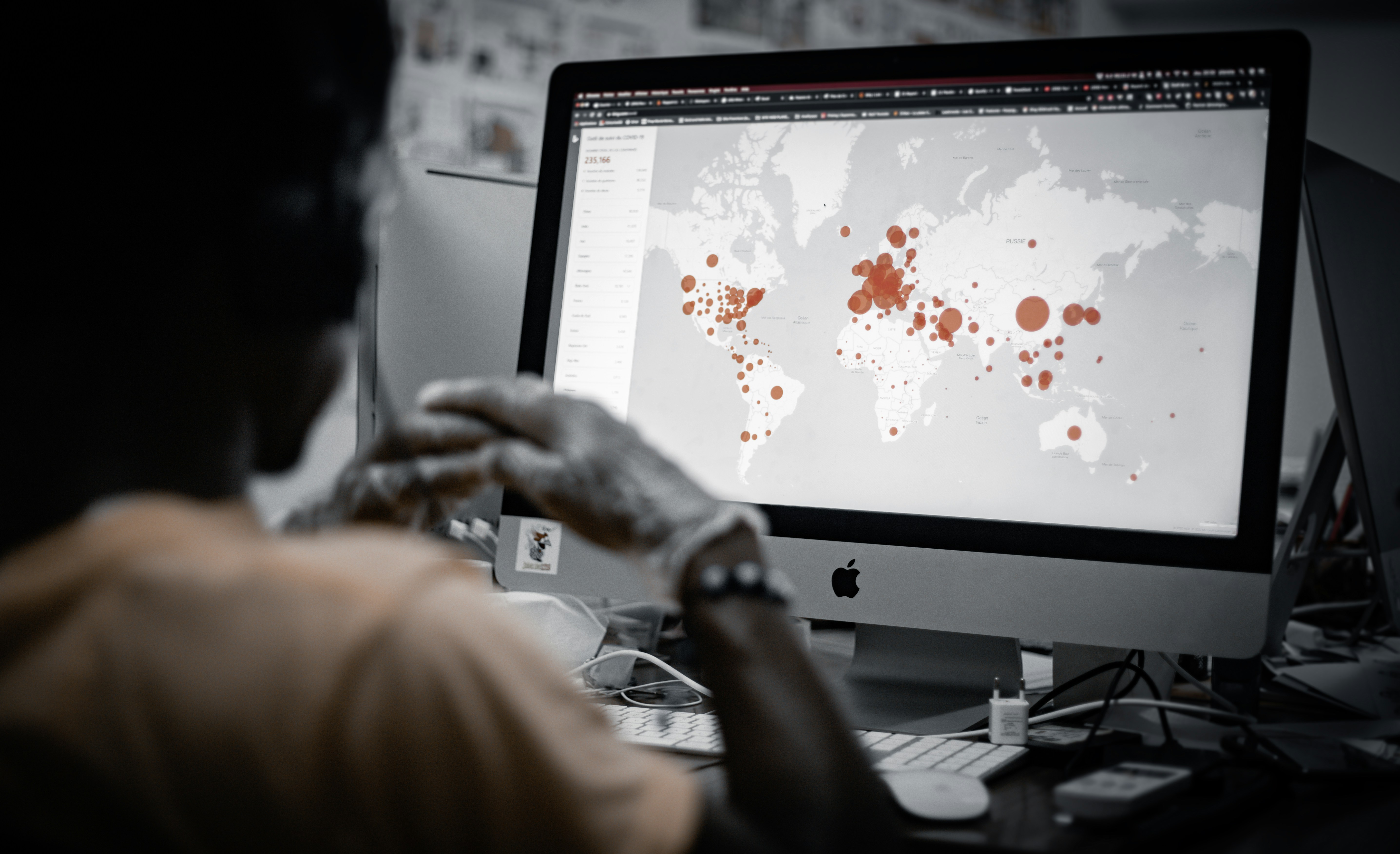 Person watching streaming service on laptop with world map overlay