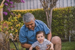 man in blue button up shirt carrying baby in black and white stripe shirt