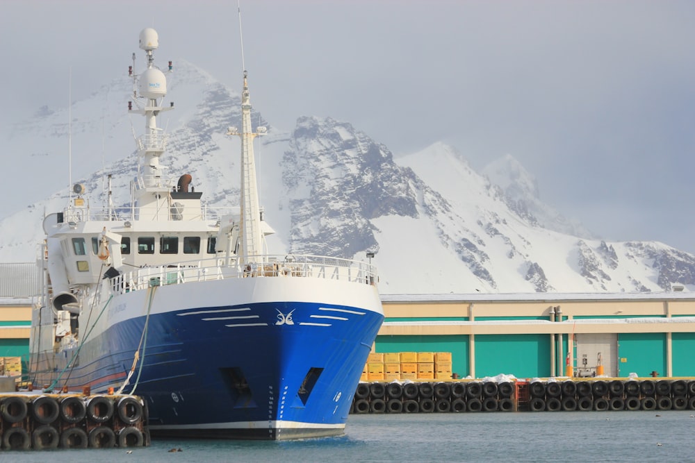 blue and white ship on dock during daytime