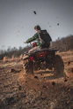 man riding red atv on brown field during daytime