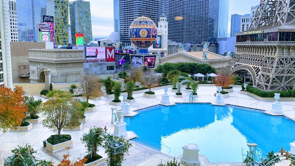 swimming pool surrounded by green trees and buildings during daytime