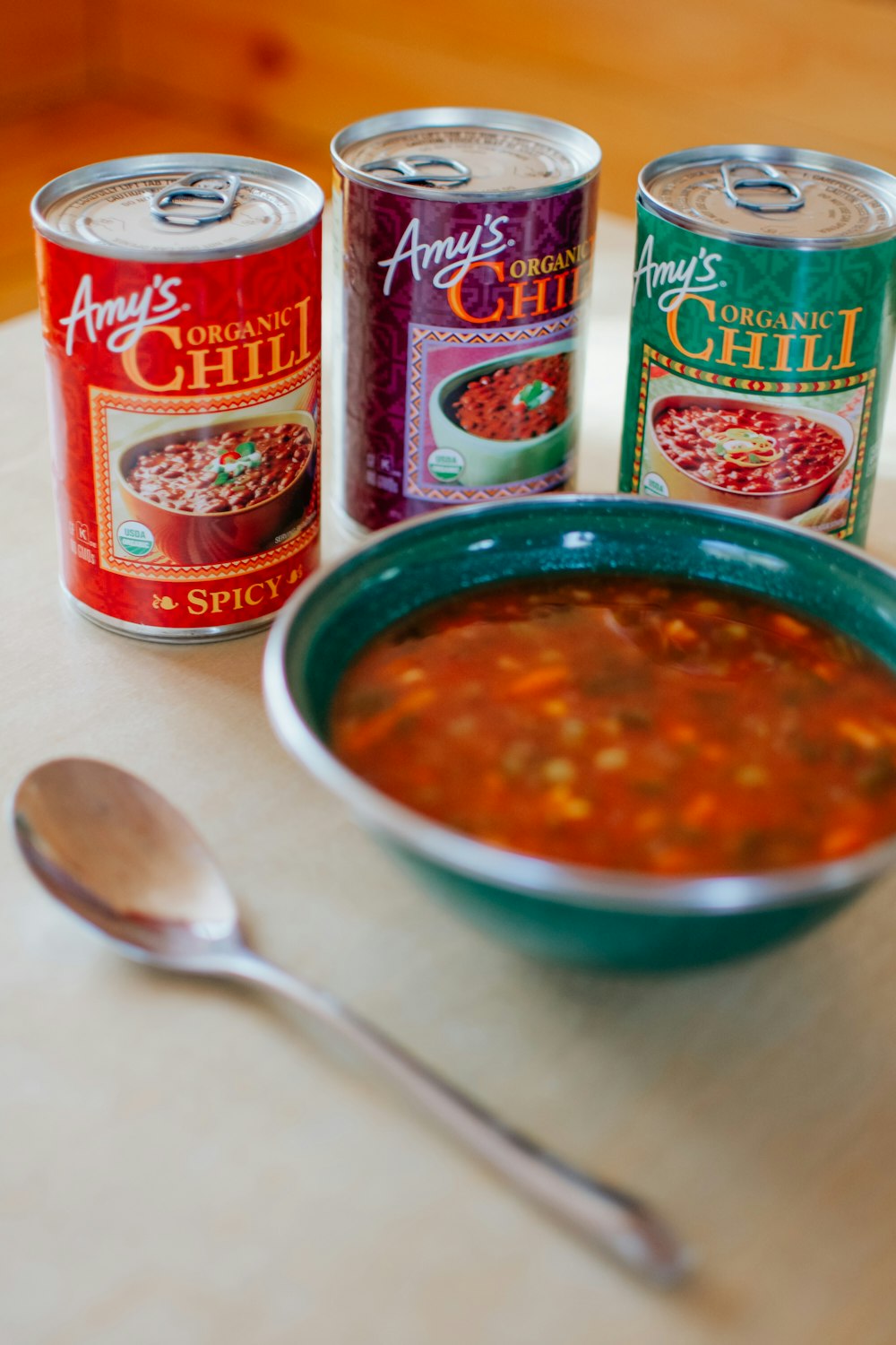 red and white labeled can beside stainless steel spoon