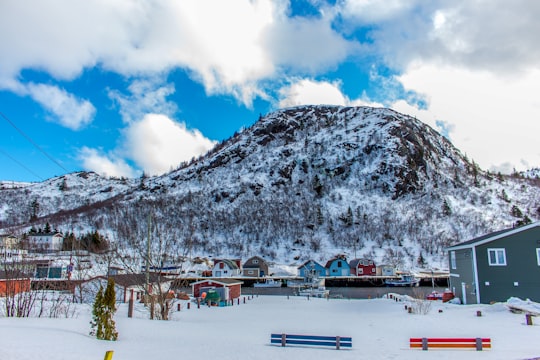 snow covered mountain under blue sky during daytime in Petty Harbour Canada