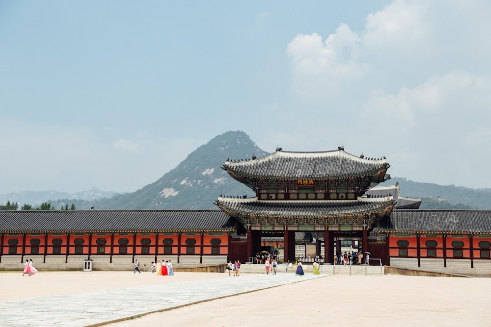 red and black temple near green mountain under blue sky during daytime