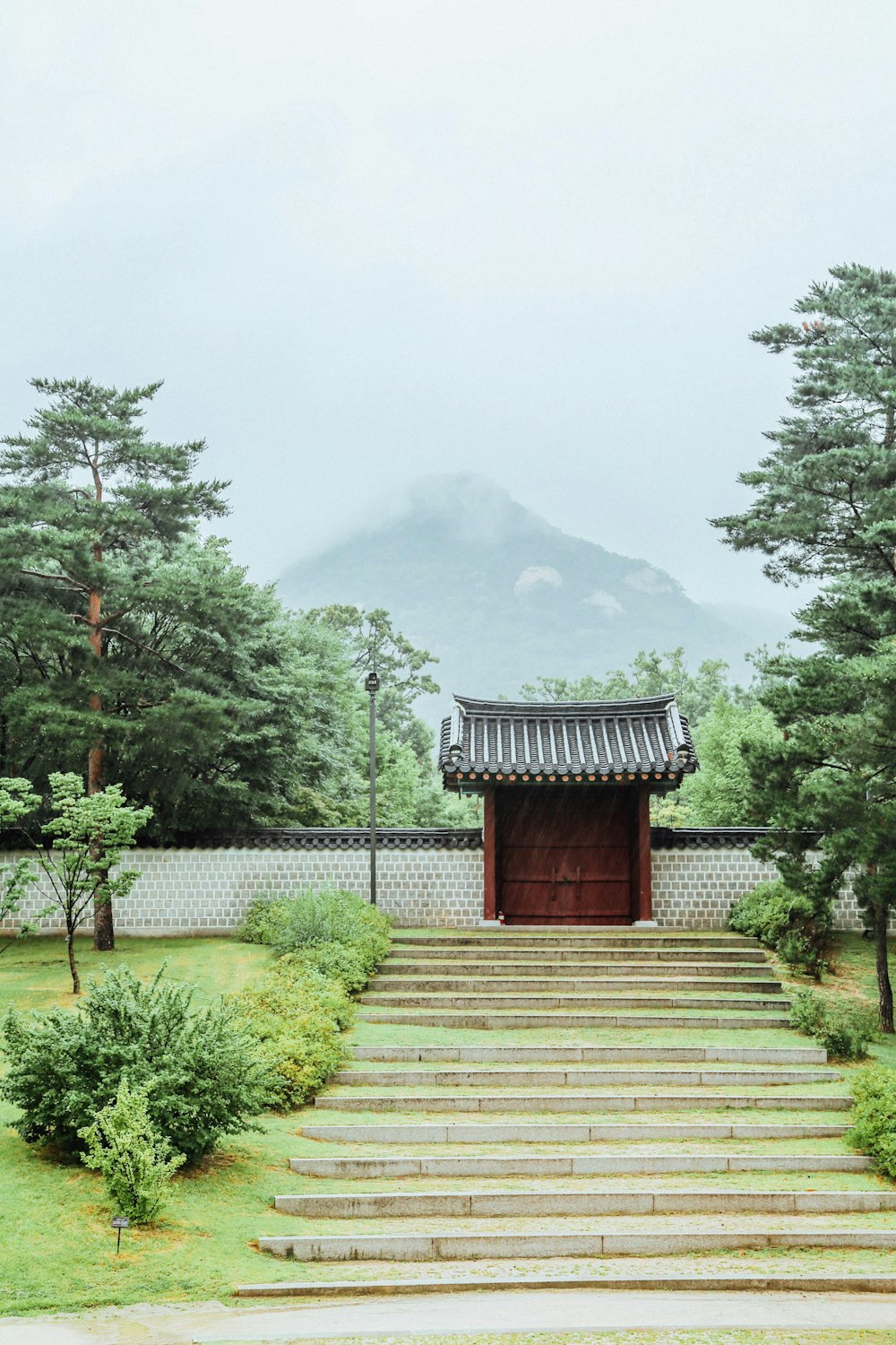 brown wooden house near green trees and mountain during daytime