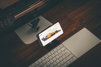 a cell phone sitting on top of a desk next to a keyboard