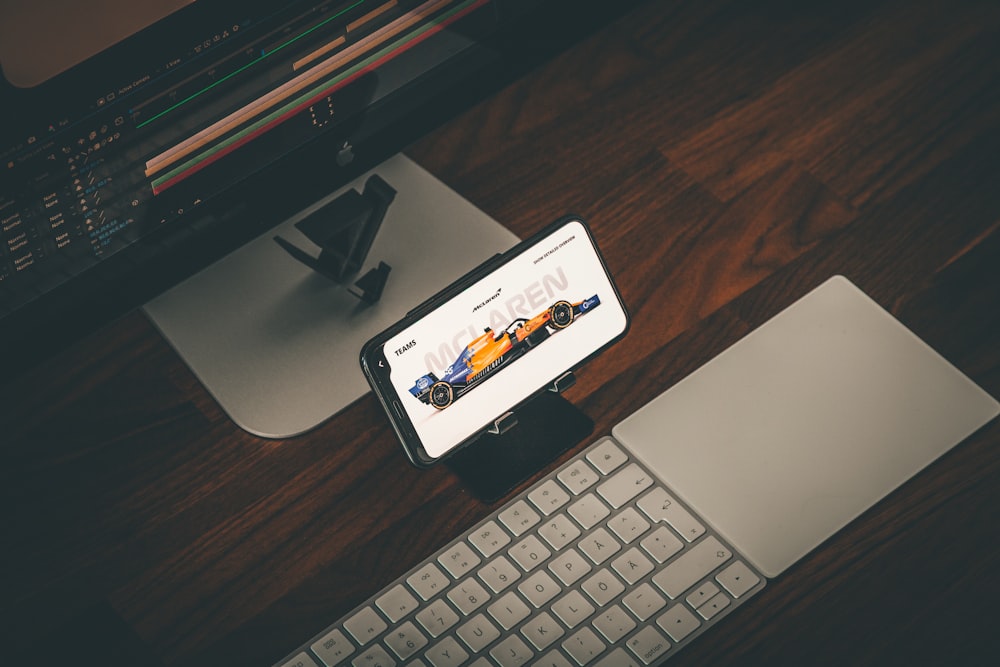 a cell phone sitting on top of a desk next to a keyboard