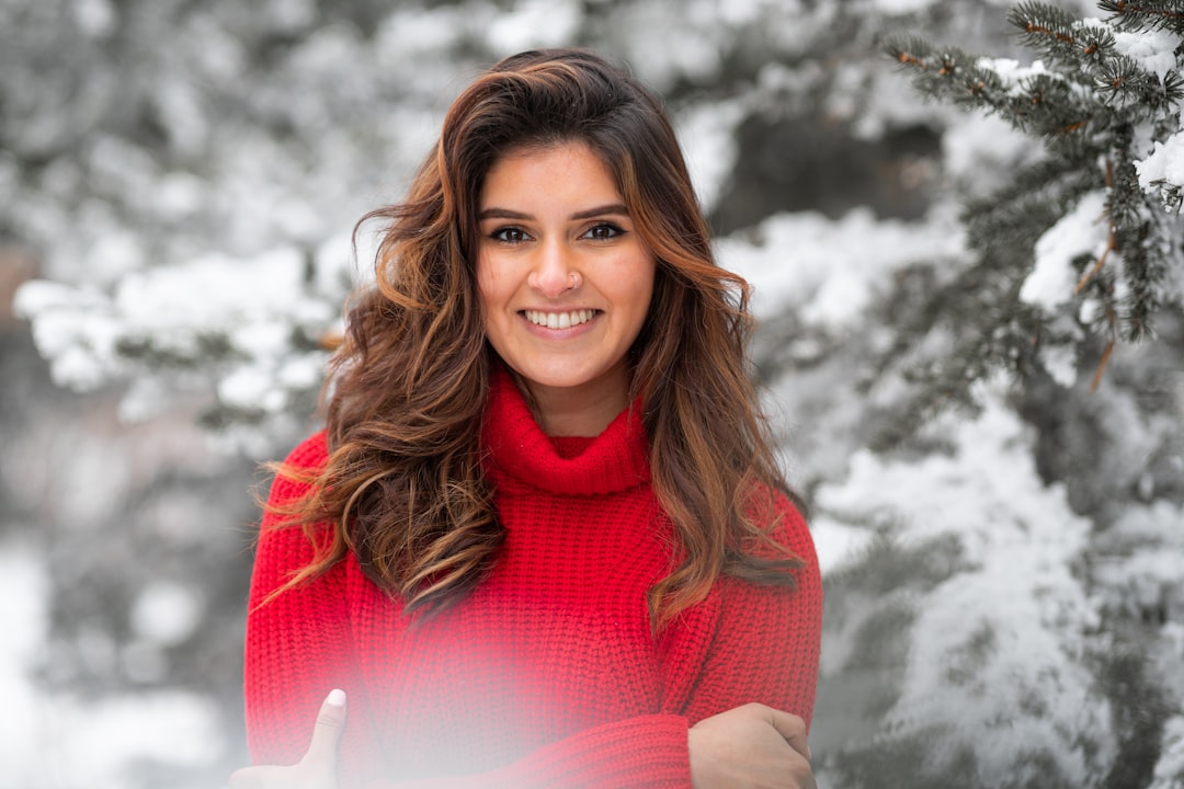 woman in red turtleneck sweater smiling